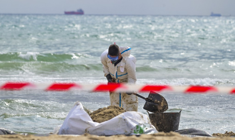 Un técnico trabaja para limpiar la playa de El Saler en el Parque Natural de la Albufera, después de que el ayuntamiento de Valencia cerrara tres playas de la costa mediterránea tras un presunto derrame de petróleo o combustible en la arena, en Valencia el 17 de julio de 2024