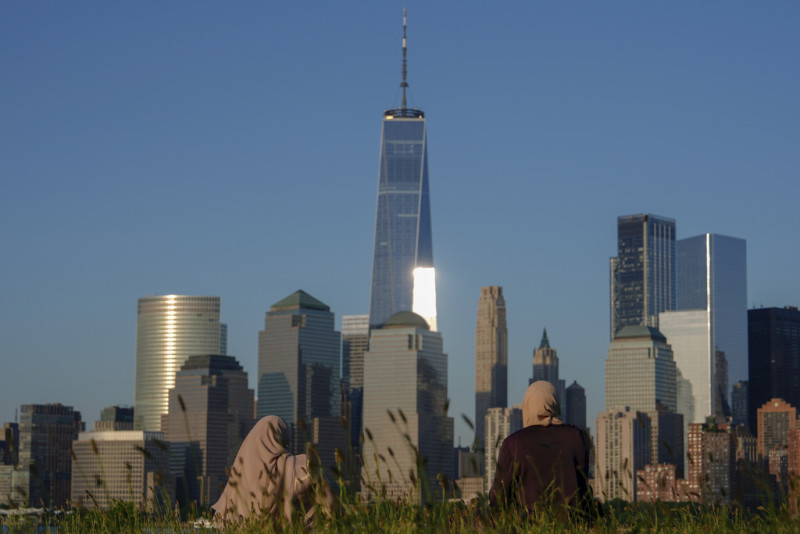Un grupo de personas mira el horizonte de Ciudad de Nueva York al atardecer, el domingo 16 de junio de 2024, en Jersey City, Nueva Jersey