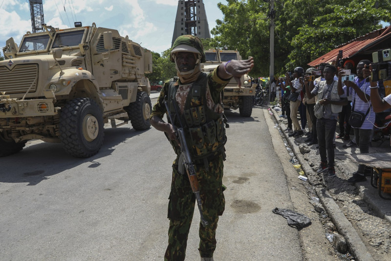 Un policía keniano que forma parte de una fuerza multinacional respaldada por la ONU hace un gesto a los periodistas para que se muevan en Puerto Príncipe.