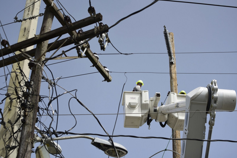 Una brigada de la Autoridad de Energía Eléctrica repara líneas de distribución dañadas por el huracán María, el 19 de octubre de 2017, en la comunidad Cantera de San Juan.