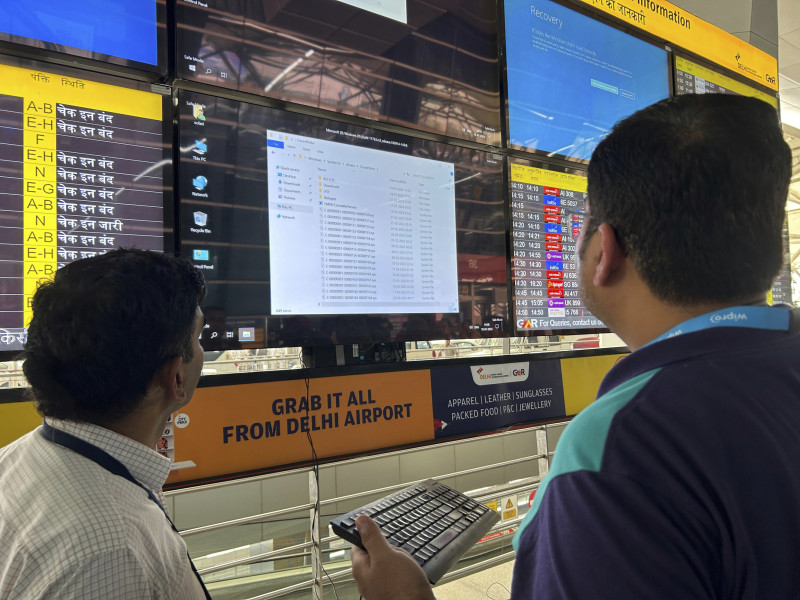Un funcionario del aeropuerto intenta reiniciar una pantalla