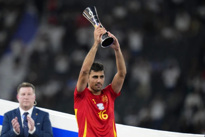 El español Rodri alza el troFeo del Mejor Jugador del torneo después de la final entre España e Inglaterra en la Euro 2024, en Berlín, Alemania, el domingo 14 de julio de 2024. España ganó 2-1.