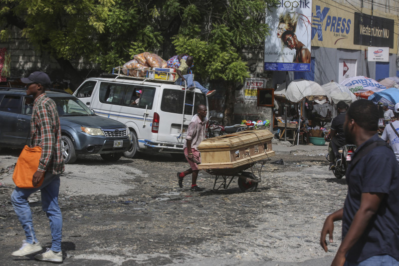 Un hombre transporta un ataúd con una carretilla en Puerto Príncipe