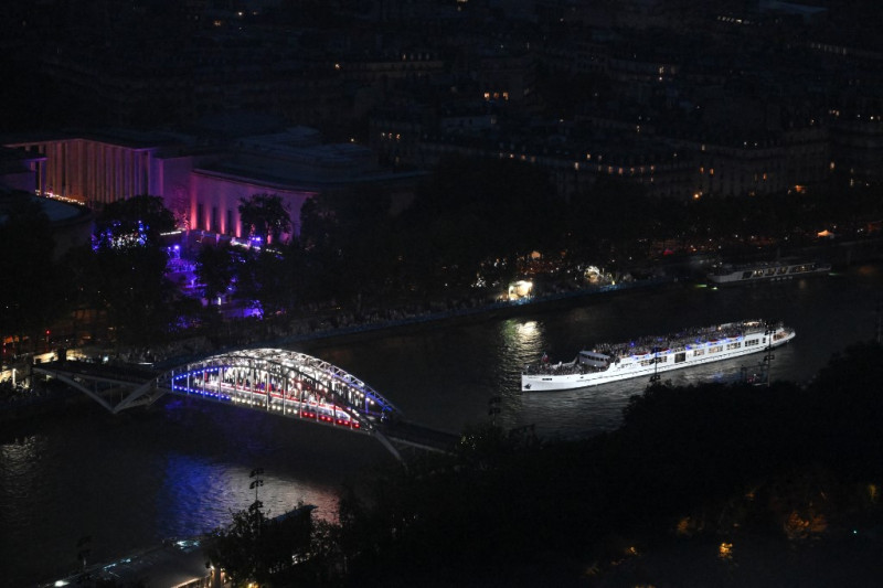 Un barco con la delegación de Francia pasa junto a la pasarela Debilly mientras navega por el río Sena durante la ceremonia de inauguración de los Juegos Olímpicos de París 2024
