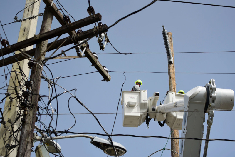 Una brigada de la Autoridad de Energía Eléctrica repara líneas de distribución dañadas por el huracán María en San Juan, el 19 de octubre de 2017.
