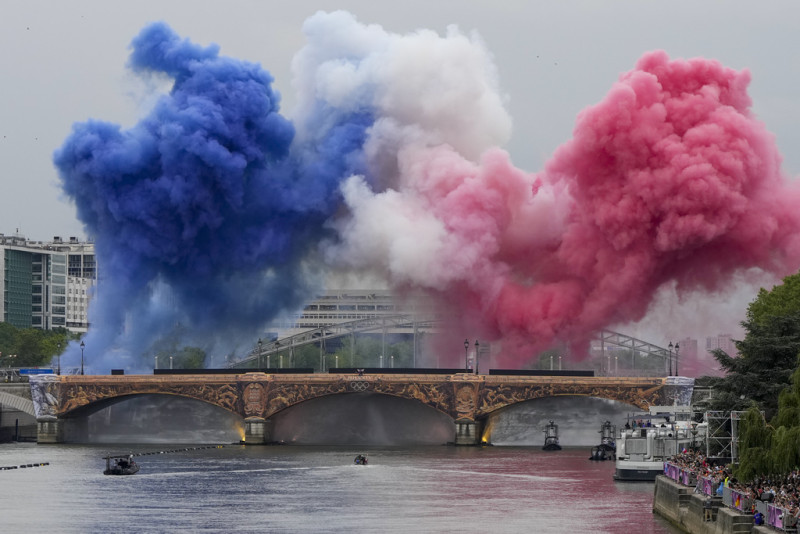 Humo ceremonial con los colores de la bandera de Francia aparece sobre el río Sena en París, Francia, durante la ceremonia de apertura de los Juegos Olímpicos de Verano de 2024, el viernes 26 de julio de 2024