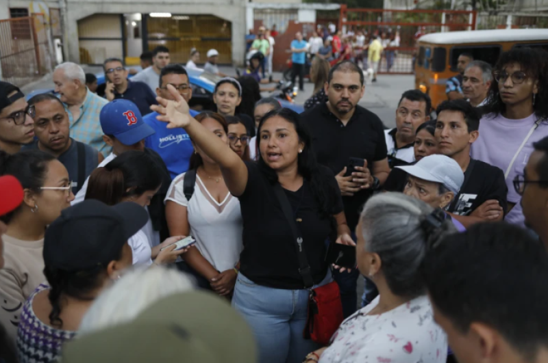 Simpatizantes de la oposición escuchan a la organizadora Deillily Rodriguez mientras se reúnen para ver el conteo de las actas de votación en las elecciones presidenciales en Caracas, Venezuela, el domingo 28 de julio de 2024. (AP Foto/Cristian Hernández)