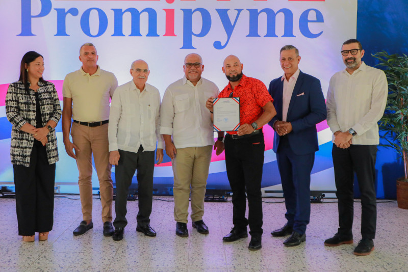 El director de Promipyme, Fabricio Gómez Mazara, junto al senador de la provincia Valverde, Odalis Rodríguez, posan con los beneficiarios.