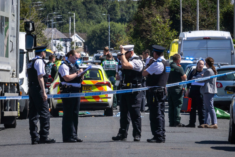 La policía asegura el área donde un hombre fue detenido por apuñalar ayer a varias personas, en Southport, Merseyside, Inglaterra.