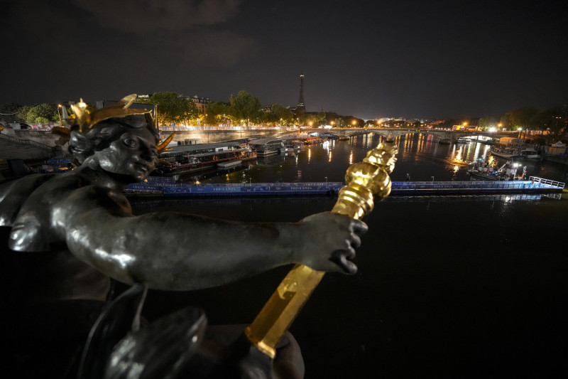 Los empleados remueven la embarcación para las competencias de triatlón de los Juegos Olímpicos de París luego que la prueba fue aplazada debido a la condición del agua en el río Sena, el martes 30 de julio de 2024.