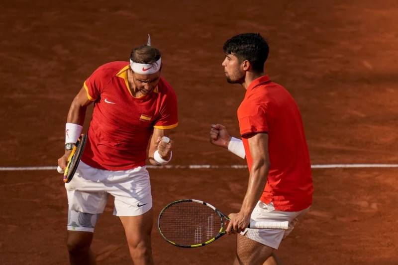 El español Carlos Alcaraz, a la derecha, y Rafael Nadal, de España celebran un punto ante Tallon Griekspoor y Wesley Koolhof de Holanda durante el partido de dobles de los Juegos Olímpicos en el estadio de Roland Garros.
