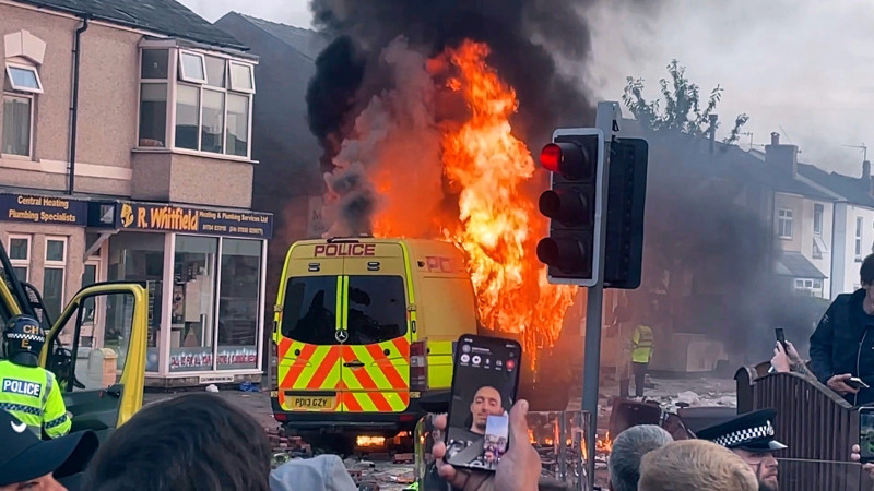 Una patrulla arde durante un enfrentamiento entre una turba y la policía, el martes, 30 de julio 2024, en Southport, en el noroeste de Inglaterra.