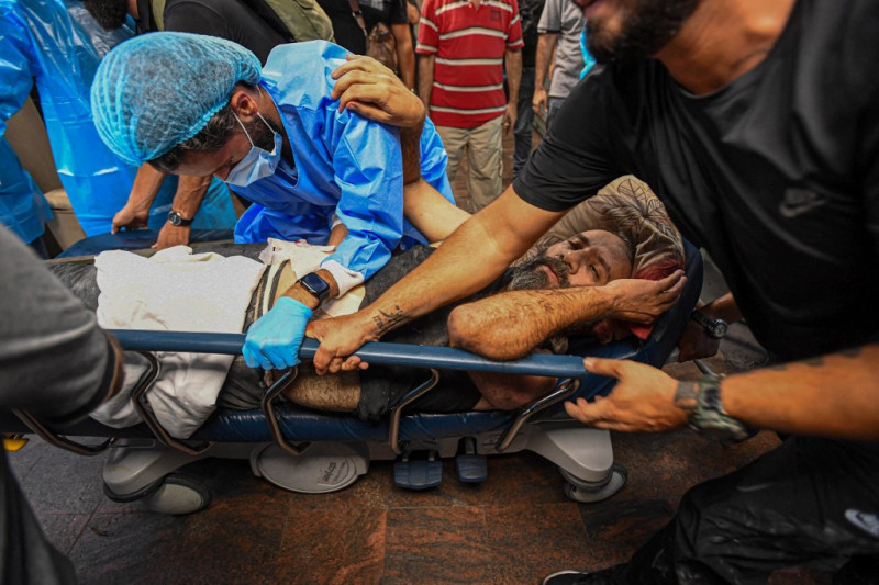 Personal médico transporta a un hombre herido en una camilla en el hospital de Bahman tras un ataque militar israelí contra un edificio en el suburbio del sur de Beirut.