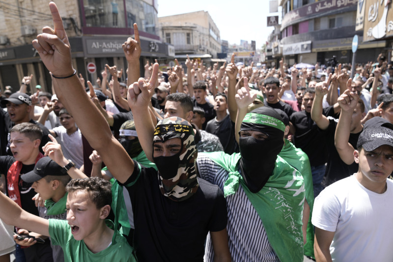 Palestinos llevan pañuelos y cintas para la cabeza del grupo militante Hamas