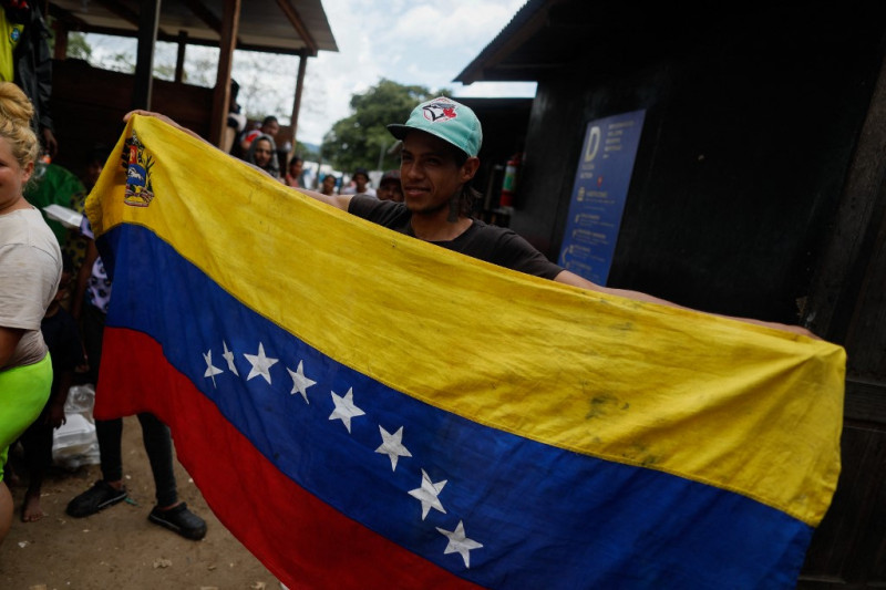 Un migrante venezolano sostiene la bandera venezolana durante su estadía en la Estación de Recepción de Migrantes en Lajas Blancas, provincia de Darién, Panamá, el 6 de octubre de 2023.