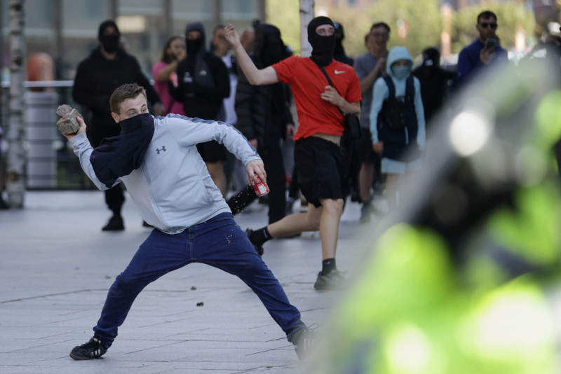 Un manifestante lanza un ladrillo durante una protesta en Liverpool