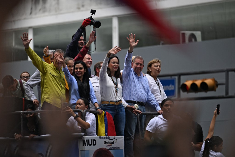 La líder opositora venezolana María Corina Machado (centro) y el candidato presidencial opositor Edmundo González Urrutia (segundo por la derecha) saludan a sus partidarios durante una manifestación frente a la sede de las Naciones Unidas en Caracas el 30 de julio de 2024.