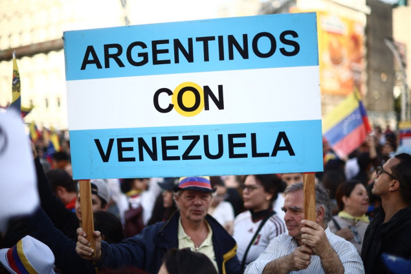 Hombres sostienen un cartel que dice "Argentinos con Venezuela"