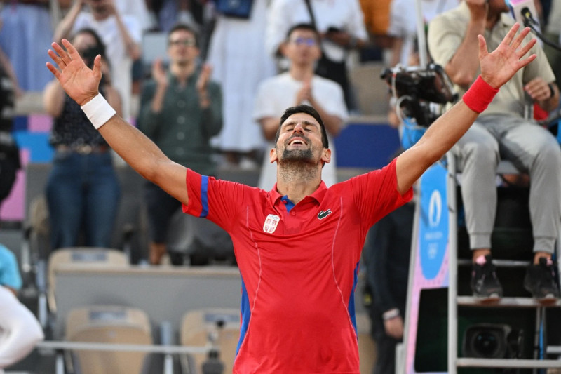 Novak Djokovic levanta los brazos en señal de satisfacción luego de vencer al español Carlos Alcaraz en dos sets.