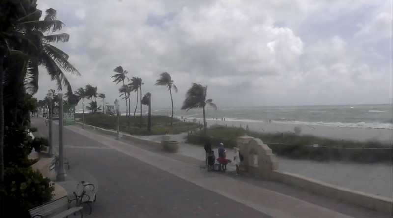 Gente camina por una playa mientras la tormenta tropical Debby avanza por el Golfo de México hacia Florida el 4 de agosto de 2024 en Hollywood, Florida.