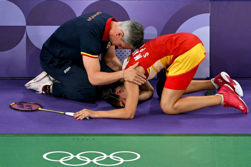 La española Carolina Marín es consolada por su entrenador Fernando Rivas