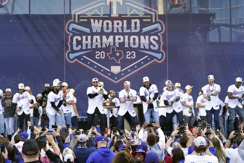 Los Rangers de Texas arrojan champaña a los fanáticos durante la celebración del título de la Serie Mundial, el viernes 3 de noviembre de 2023.