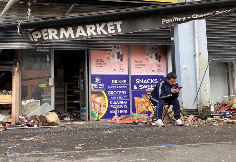 Abdelkader Mohamad Al Alloush, propietario del supermercado Sham, sentado ayer frente a su tienda en Belfast, Irlanda del Norte.