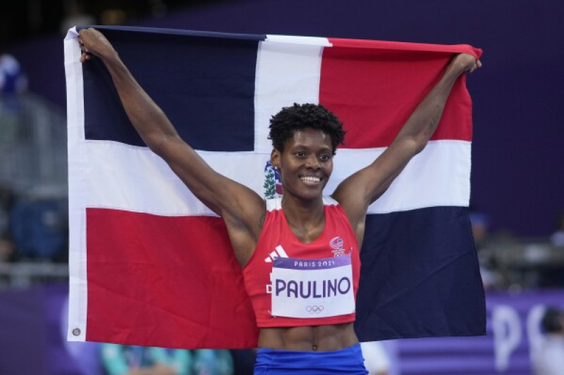 Marileidy Paulino exhibe la bandera nacional tras conquistar la presea dorada en los 400 metros en los Juegos Olímpicos y establecer una marca Olímpica.