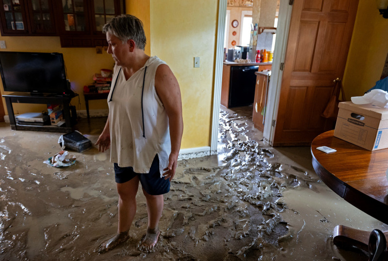 Ann Farkas camina en su vivienda dañada por inundaciones en Canisteo, Nueva York ayer, tras el paso de los remanentes de la tormenta Debby.