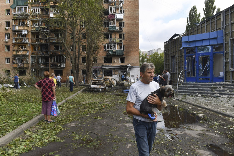 Vecinos de un edificio de apartamentos dañado tras proyectiles ucranianos abandonan la zona en Kursk, Rusia, ayer domingo.