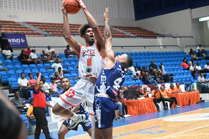 Eusebio Suero, de los Cañeros, se eleva en busca de un canasto sobre la defensa de Carlos Carela, de los Marineros, en el partido de la LNB.