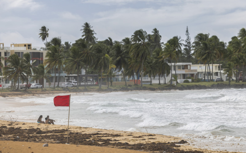 Turistas sentados en la playa La Pared