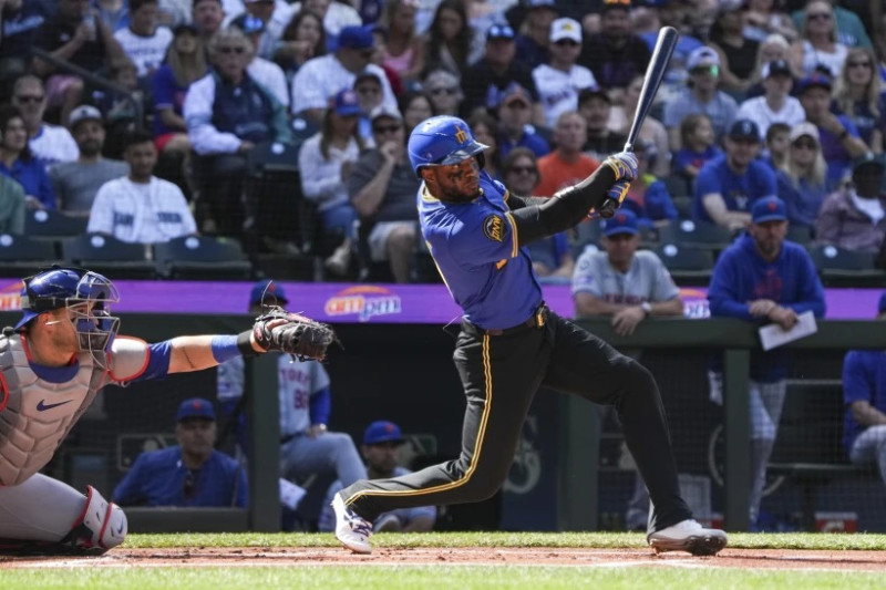 El lanzador de los Marineros de Seattle, Víctor Robles, a la derecha, batea la pelota y comete una falta durante la primera entrada de un partido contra los Mets de Nueva York, el domingo 11 de agosto de 2024, en Seattle.