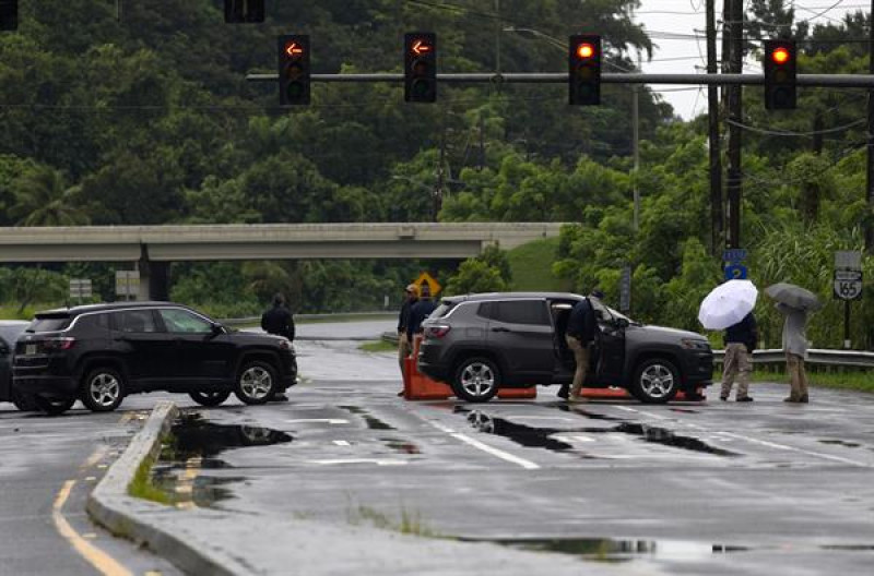 Autoridades bloquean el paso en una carretera afectada tras el paso del huracán Ernesto, este miércoles en Toa Baja (Puerto Rico).