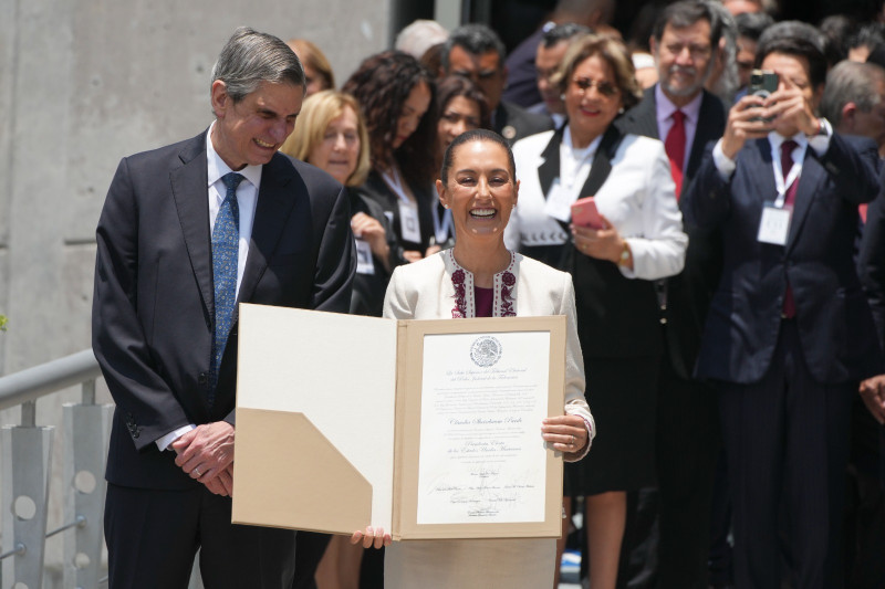 La presidenta electa Claudia Sheinbaum, acompañada de su esposo Jesús María Tarriba, sostiene el documento que la certifica ganadora de las elecciones.