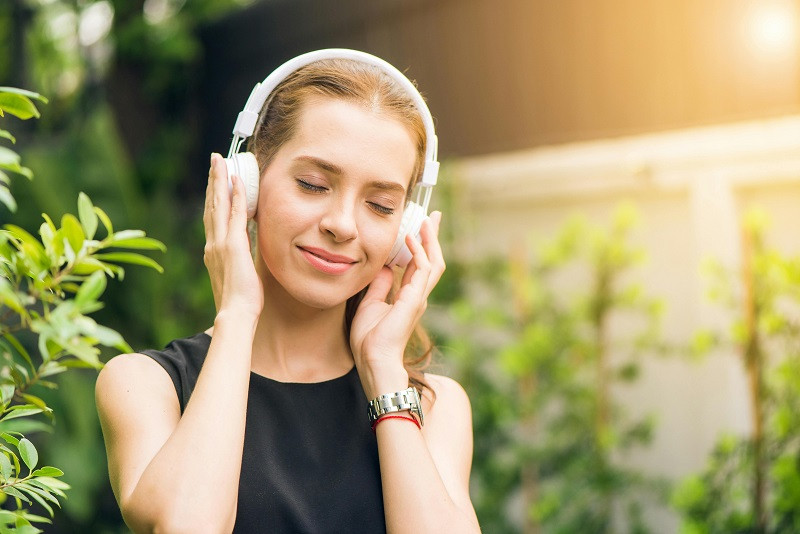 Joven con auriculares disfrutando de lo que oye.