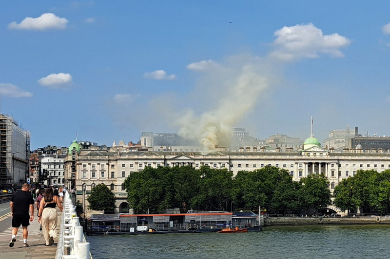 Visto desde el puente de Waterloo, se ve humo elevándose hacia el cielo desde un incendio ubicado en el techo de Somerset House junto al río Támesis en Londres el 17 de agosto de 2024. Alrededor de 100 bomberos abordaron un gran incendio en el histórico centro cultural Somerset House de Londres el sábado. , con imágenes publicadas en las redes sociales que muestran llamas saliendo de debajo de su techo.