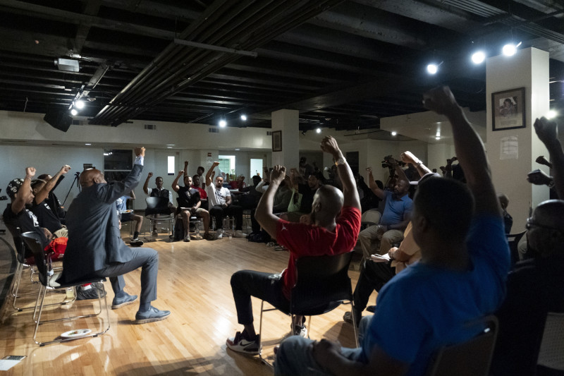 Panelistas y asistentes levantan los puños durante una reunión de Black Man Lab para debatir la candidatura de la vicepresidenta Kamala Harris, el lunes 22 de julio de 2024, en Atlanta.