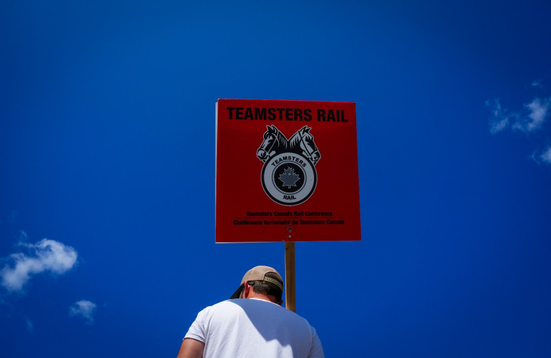 Un trabajador muestra un letrero de Teamsters Rail en una playa ferroviaria de Canadian Pacific Kansas City, ayer en Smiths Falls, Ontario, Canadá.