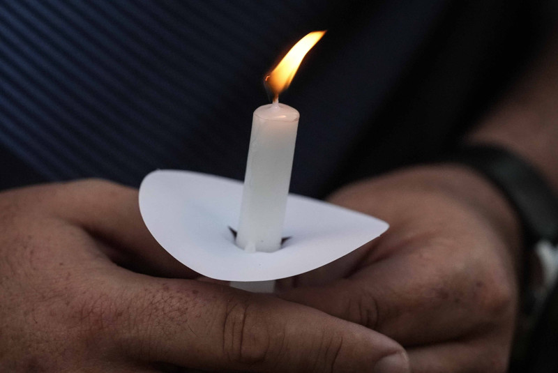 Mark Gorman sostiene una vela durante una vigilia en honor a los alumnos y maestros asesinados en la secundaria Apalachee, el miércoles 4 de septiembre de 2024, en Winder, Georgia.