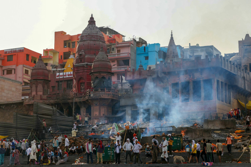 En esta fotografía tomada el 16 de junio de 2024, se elevan columnas de humo mientras arden piras funerarias en Manikarnika Ghat, a lo largo de las orillas del río Ganges en Varanasi.