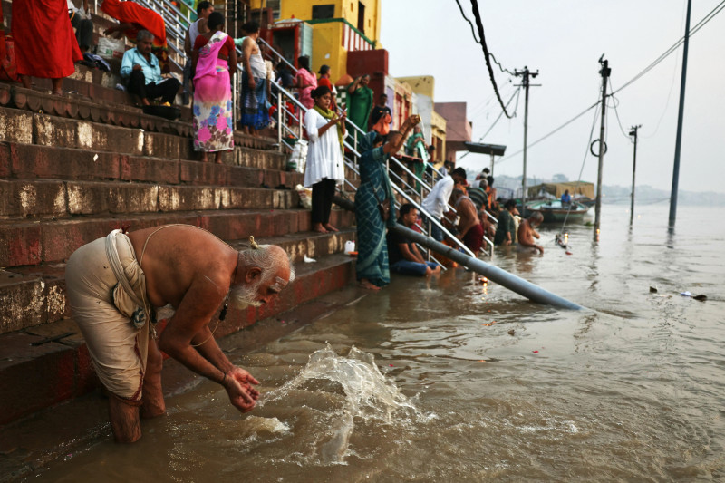 En esta fotografía tomada el 31 de agosto de 2024, los devotos hindúes ofrecen oraciones al dios Sol a lo largo de las orillas del río Ganges, en Varanasi.