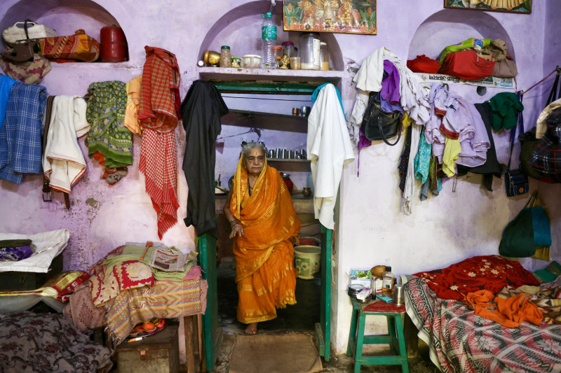 En esta fotografía tomada el 22 de agosto de 2024, la residente Gulab Bai sale de la cocina de su casa en el complejo Kashi Vaas de Mumukshu Bhawan, un hospicio para buscadores de la salvación en Varanasi.