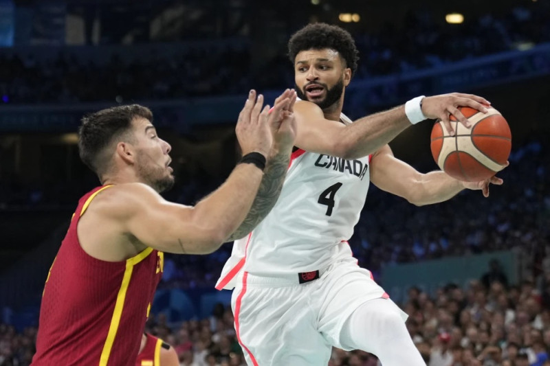 Jamal Murray, a la derecha, de Canadá, intenta pasar el balón ante Willy Hernangómez, a la izquierda, de España, en un partido en los Juegos Olímpicos.