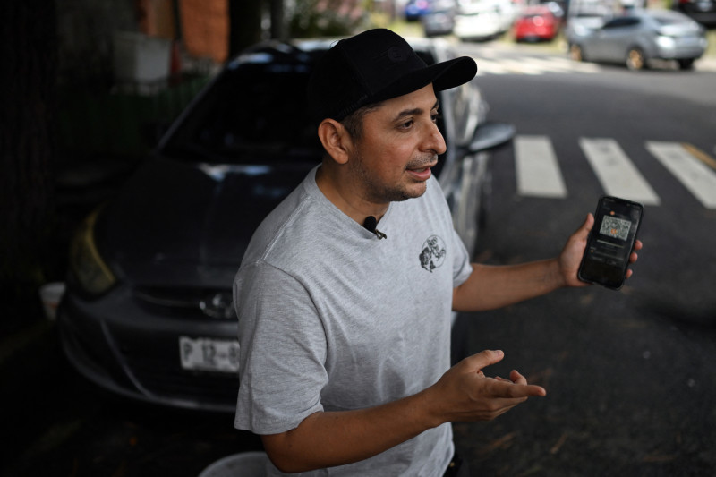 Taxi driver Napoleon Osorio shows an app on his phone that he uses to charge his rides in bitcoins in San Salvador on September 4, 2024.