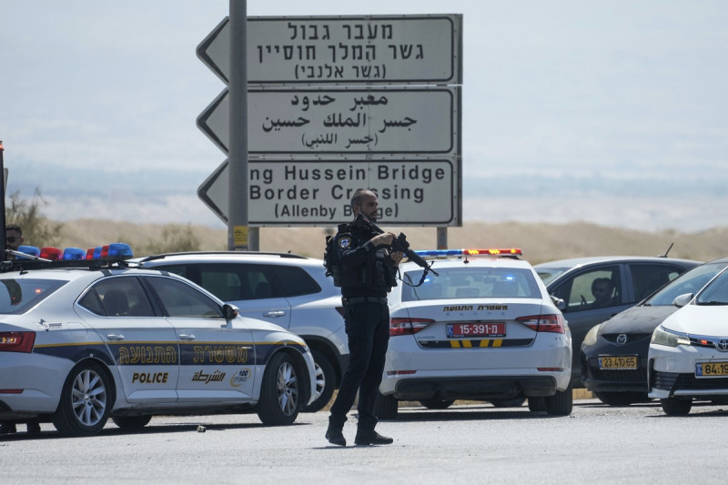 La policía israelí monta guardia cerca del lugar de un tiroteo mortal donde las autoridades israelíes dicen que tres personas fueron asesinadas a tiros en el cruce del puente fronterizo Allenby entre Cisjordania y Jordania, ayer.