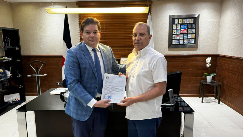 Adriano Abreu, presidente de la Federación de Automovilismo, entrega a su homólogo del Comité Olímpico Dominicano, Garibaldy Bautista, los documentos en el que solicita su integración.