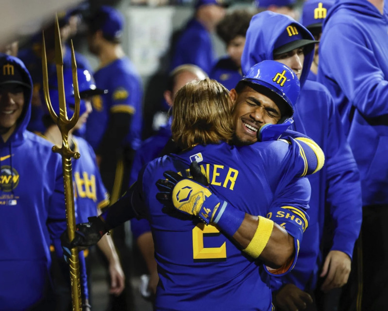 Julio Rodríguez, de los Marineros, recibe un abrazo de su compañero JustinTurner, luego de dar su tablazo ganador.