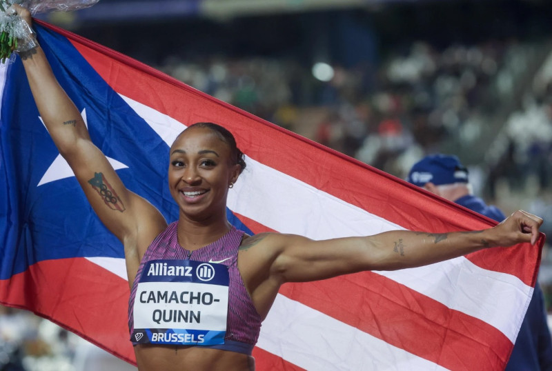 Jasmine Camacho-Quinn exhibe orgulla la bandera de Puerto Rico tras ganar la carrera.