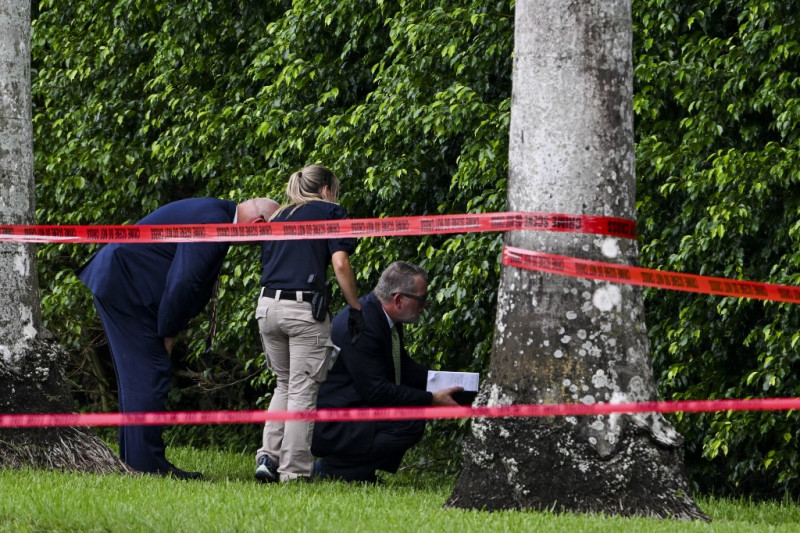 Los agentes del orden trabajan en la escena del crimen fuera del Trump International Golf Club en West Palm Beach, Florida, el 16 de septiembre de 2024, tras el intento de asesinato del domingo contra el expresidente estadounidense y candidato presidencial republicano Donald Trump.